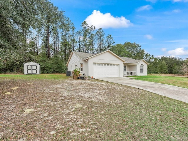 single story home with central AC unit, a garage, a storage shed, and a front lawn