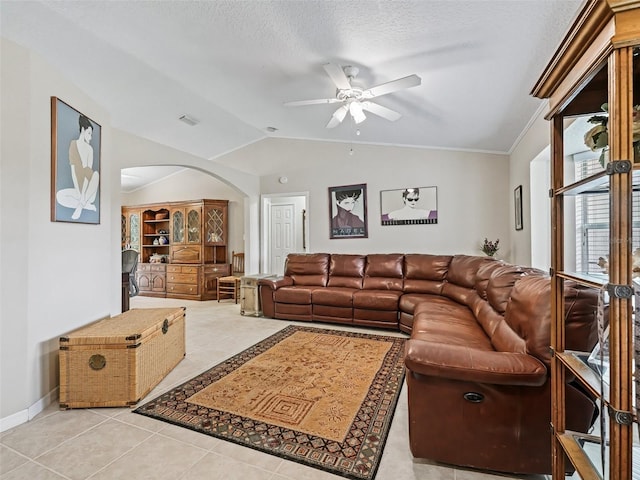 tiled living room featuring ceiling fan, lofted ceiling, and a textured ceiling