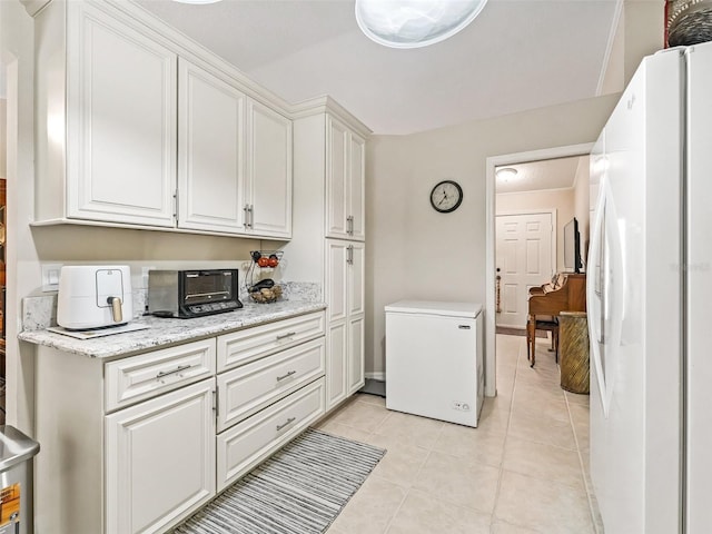 kitchen with white refrigerator, fridge, and white cabinets