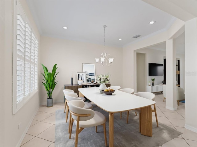 dining room with light tile patterned floors, ornamental molding, and a chandelier