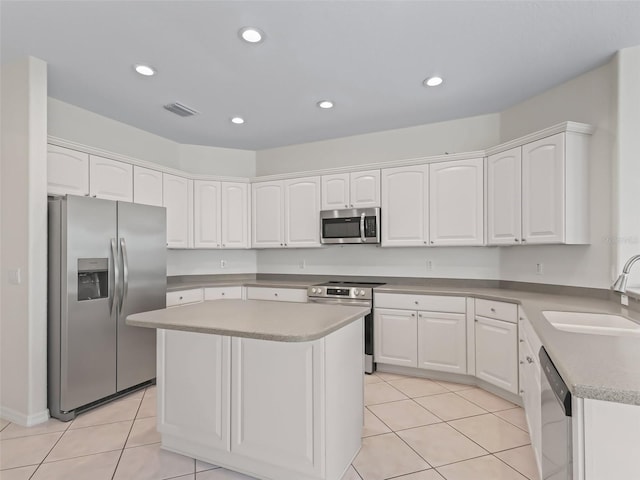 kitchen with a kitchen island, white cabinetry, appliances with stainless steel finishes, and sink