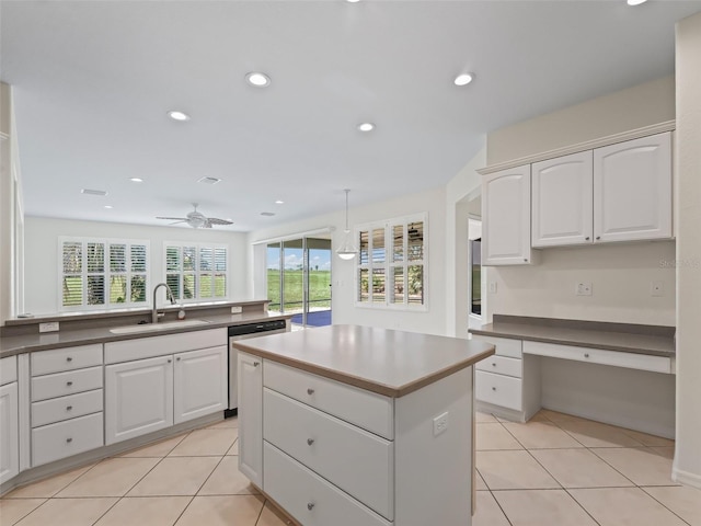 kitchen with light tile patterned floors, decorative light fixtures, sink, and white cabinets