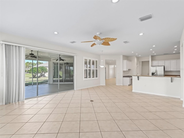 unfurnished living room featuring light tile patterned flooring and ceiling fan