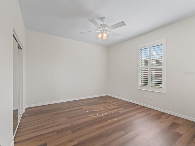 empty room featuring dark wood-type flooring and ceiling fan