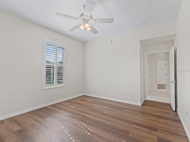 spare room featuring dark wood-type flooring and ceiling fan