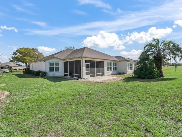 rear view of house with a yard and a sunroom