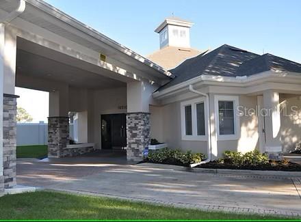 view of exterior entry with stone siding and stucco siding