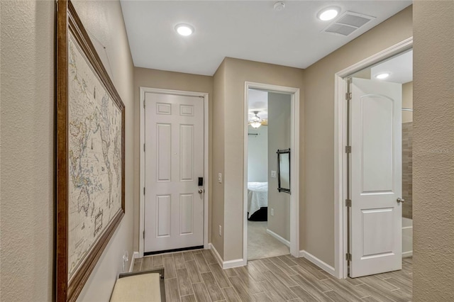 doorway to outside with wood finish floors, visible vents, and baseboards