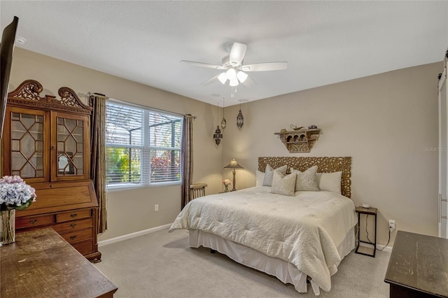 bedroom featuring light carpet, a ceiling fan, and baseboards