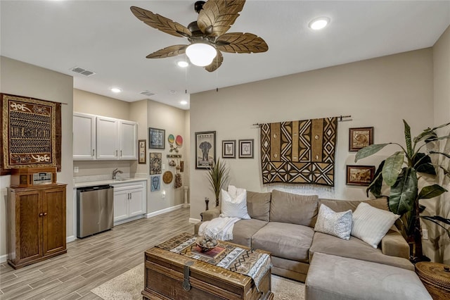 living room with visible vents, baseboards, light wood-style flooring, ceiling fan, and recessed lighting