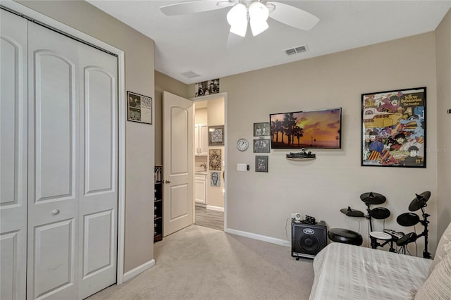 bedroom featuring light carpet, a ceiling fan, visible vents, baseboards, and a closet