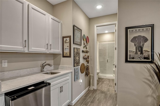 interior space featuring a sink, laundry area, wood finished floors, and baseboards