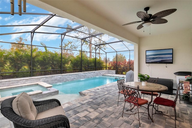 view of swimming pool featuring a patio area, a lanai, a pool with connected hot tub, and a ceiling fan