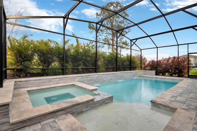 view of pool with a patio area, glass enclosure, and a pool with connected hot tub