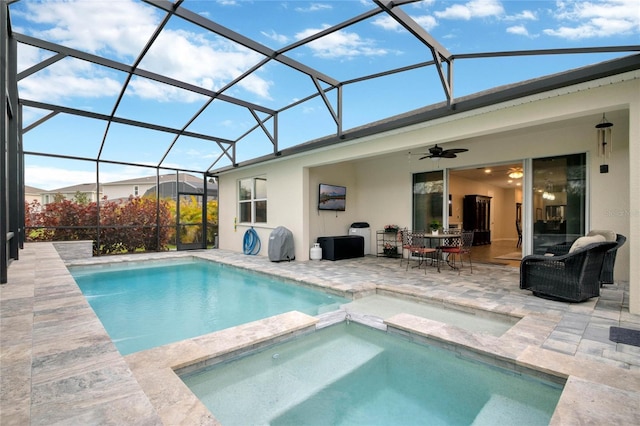 view of swimming pool featuring a lanai, ceiling fan, a pool with connected hot tub, and a patio