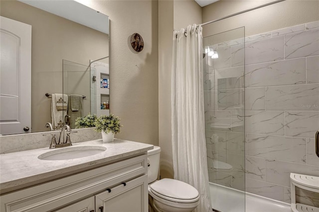 bathroom featuring toilet, a textured wall, tiled shower, and vanity