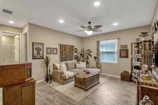 living room with ceiling fan, wood finish floors, visible vents, and baseboards