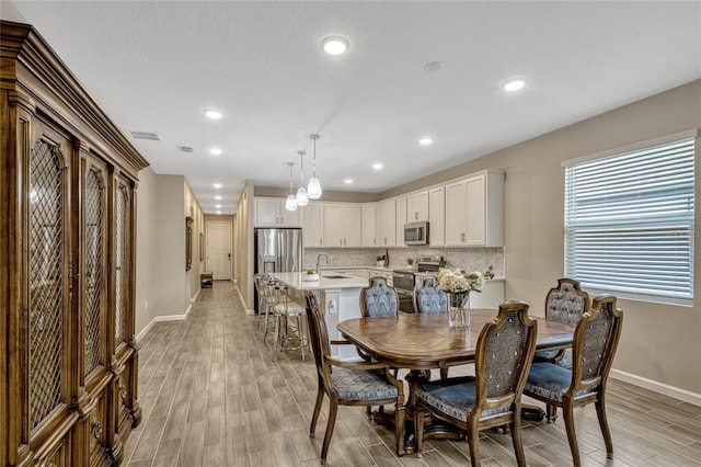 dining area featuring recessed lighting, light wood-type flooring, and baseboards