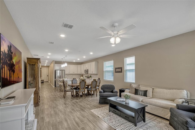 living area with a ceiling fan, recessed lighting, visible vents, and light wood-style flooring