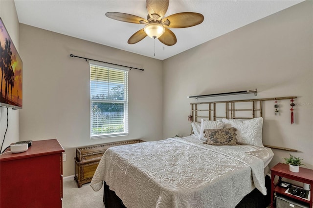 bedroom with ceiling fan, baseboards, and light colored carpet