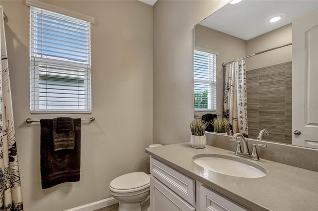 bathroom featuring toilet, a shower with curtain, baseboards, and vanity