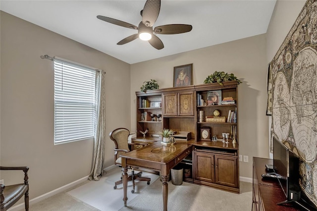 office featuring light colored carpet, a fireplace, baseboards, and ceiling fan