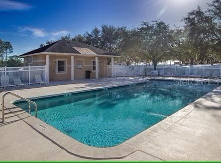 pool with fence and a patio