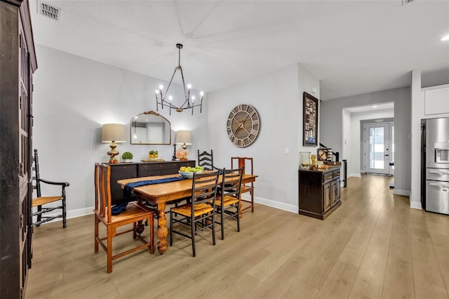 dining area featuring an inviting chandelier and light wood-type flooring