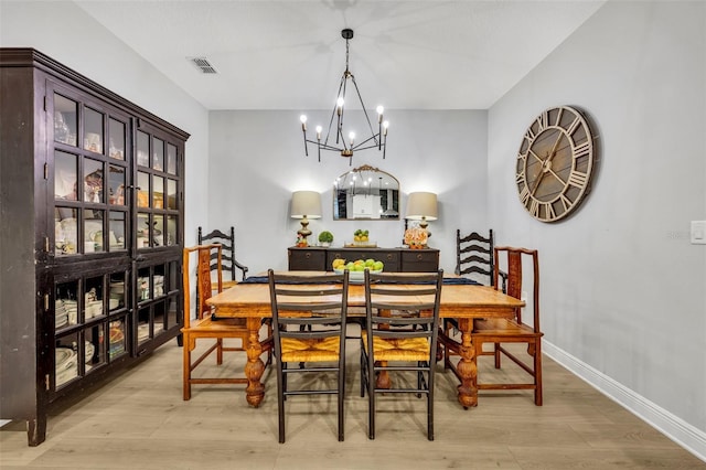 dining room with a notable chandelier and light hardwood / wood-style flooring