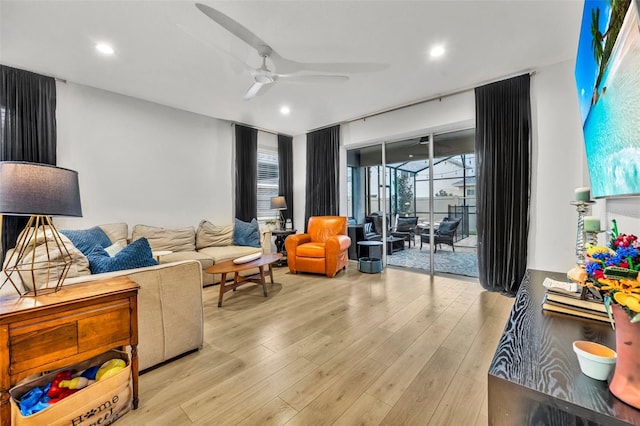 living room with ceiling fan and light hardwood / wood-style flooring