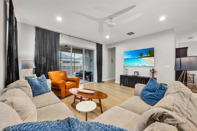 living room with light hardwood / wood-style flooring and ceiling fan