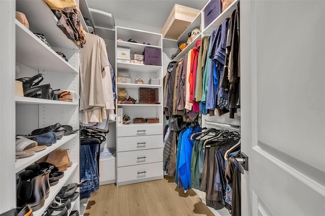 walk in closet with light hardwood / wood-style floors