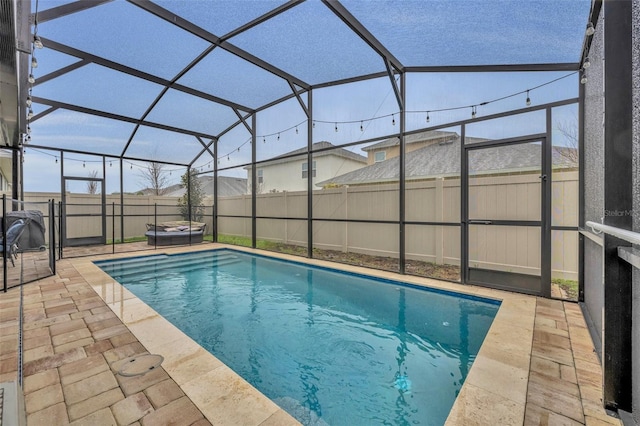 view of swimming pool featuring a lanai, a patio, and a jacuzzi