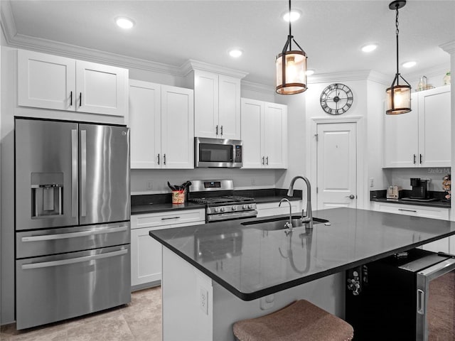 kitchen with sink, a breakfast bar area, hanging light fixtures, an island with sink, and stainless steel appliances