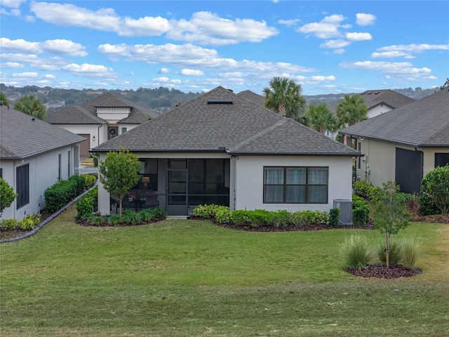 rear view of house with cooling unit and a lawn