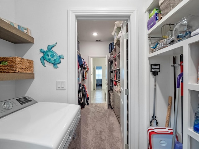 laundry area featuring washer / clothes dryer and light carpet