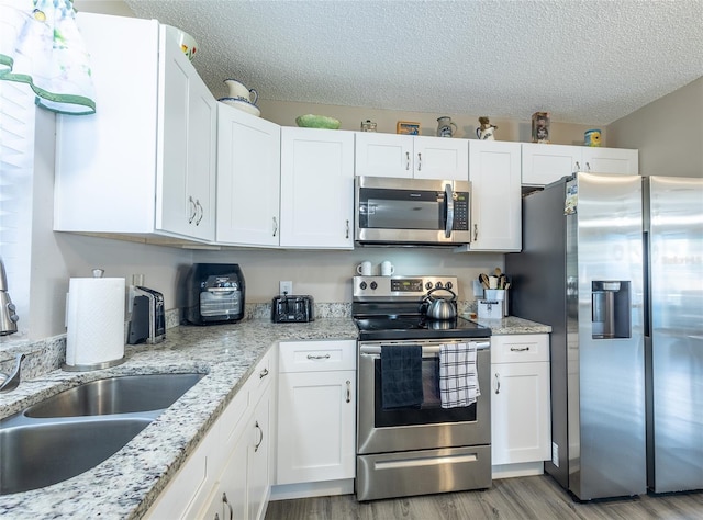 502 San Marino Dr, Lady Lake, FL 32159 - kitchen with appliances with stainless steel finishes, light hardwood / wood-style flooring, and white cabinets