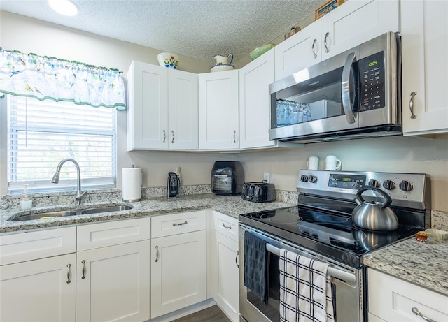 502 San Marino Dr, Lady Lake, FL 32159 - kitchen with stainless steel appliances, light stone counters, a textured ceiling, sink, and white cabinetry