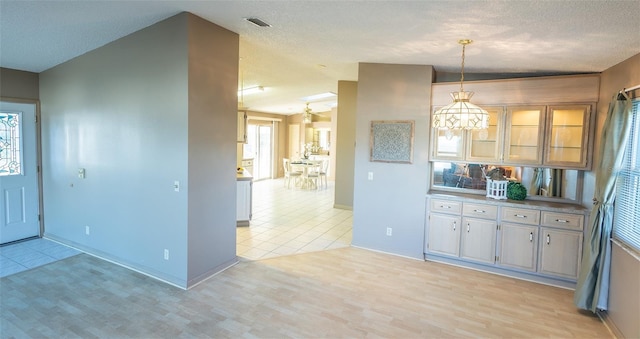 kitchen featuring decorative light fixtures, light hardwood / wood-style flooring, and a textured ceiling
