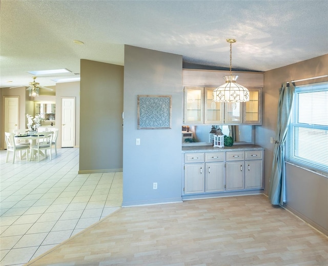 kitchen featuring pendant lighting, a textured ceiling, and light wood-type flooring