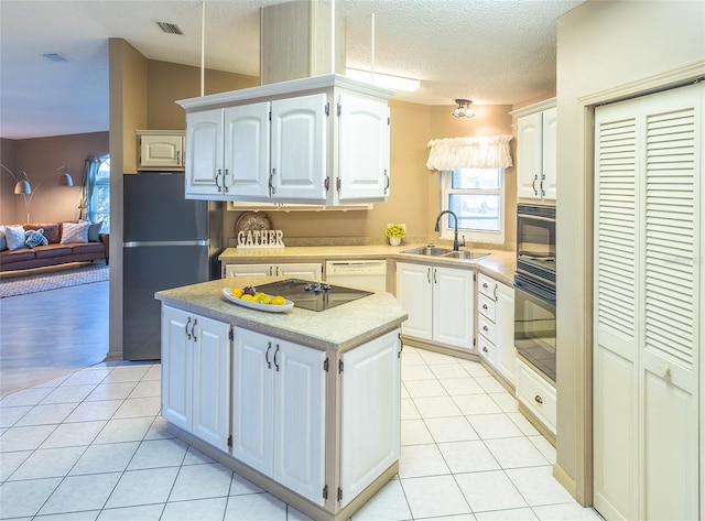 kitchen with sink, white cabinetry, black appliances, a kitchen island, and light tile patterned flooring