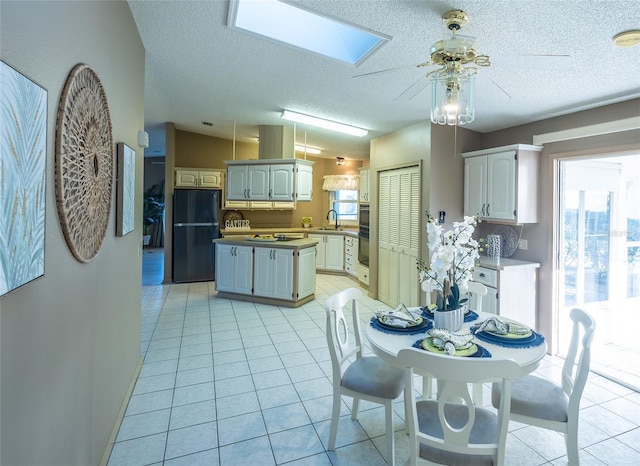 dining area featuring light tile patterned flooring, plenty of natural light, and sink
