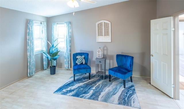 living area featuring light hardwood / wood-style floors and ceiling fan