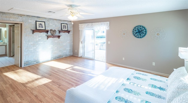 bedroom with ensuite bath, ceiling fan, a textured ceiling, access to outside, and light wood-type flooring