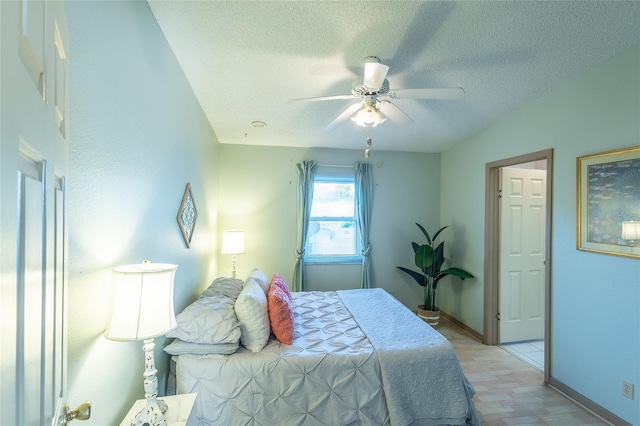 bedroom featuring ceiling fan, a textured ceiling, and light wood-type flooring