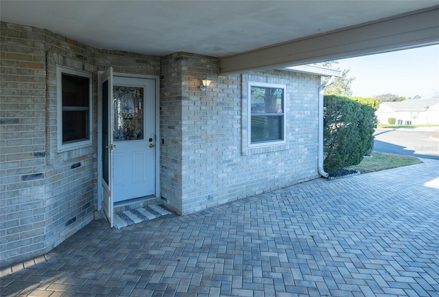 view of exterior entry featuring a patio