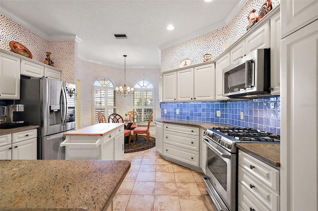 kitchen featuring white cabinetry, crown molding, stainless steel appliances, and a kitchen island