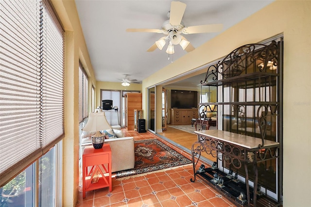 living room with tile patterned flooring, ceiling fan, and a healthy amount of sunlight