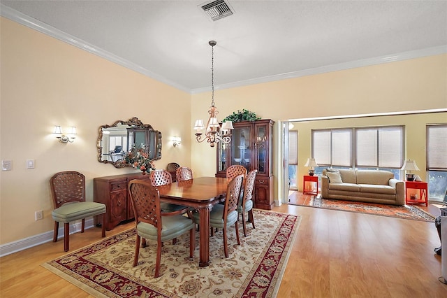 dining room featuring ornamental molding and light hardwood / wood-style flooring