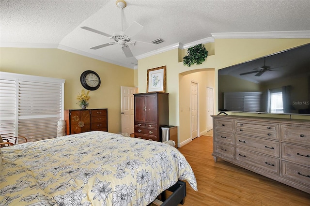 bedroom with crown molding, ceiling fan, vaulted ceiling, and a textured ceiling